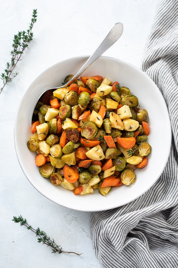 Roasted brussels sprouts and carrots in a bowl with thyme