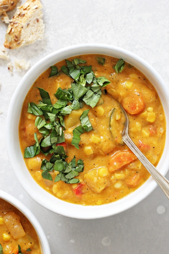 Dairy free corn chowder in a bowl with basil