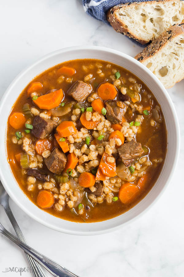 Bowl of beef and barley soup with bread