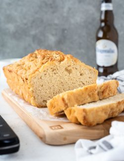 Loaf of beer bread sliced on a cutting board
