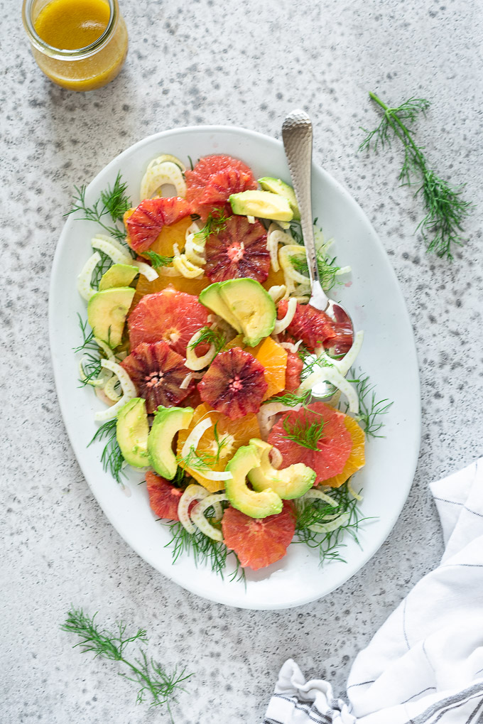 Fennel citrus salad on a white platter with a spoon