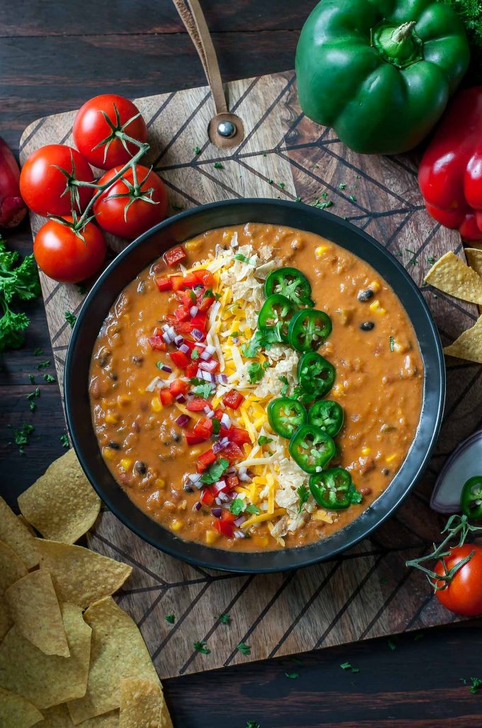 Vegetarian lentil tortilla soup with cheese and jalapeno toppings