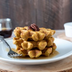 Stack of sweet potato waffles on a white plate