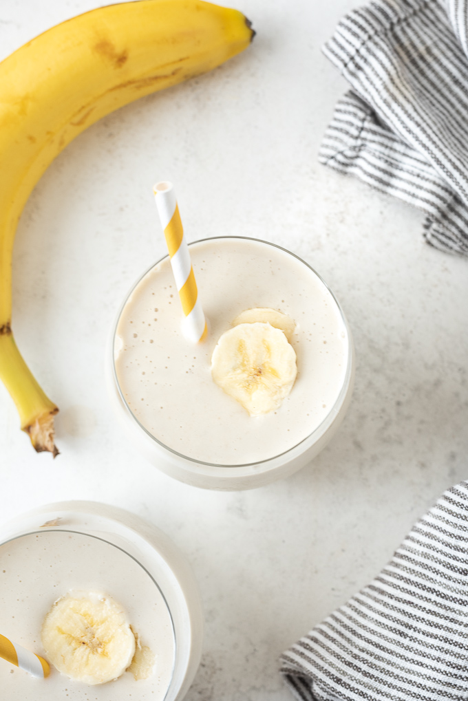 Banana smoothie recipe with straw and slice of banana on top