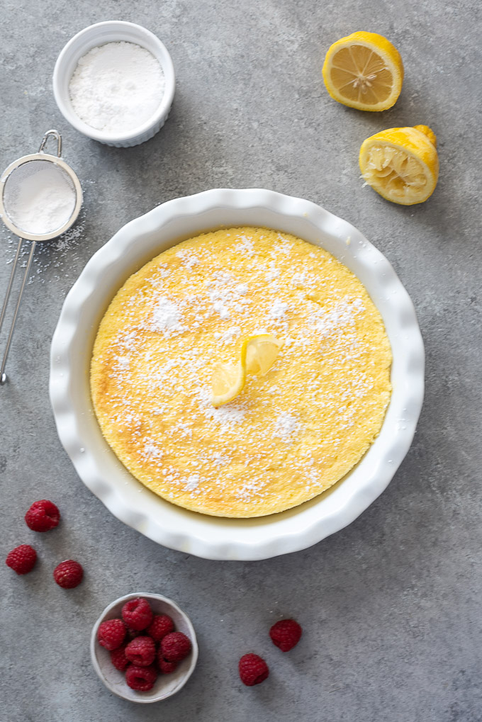 Lemon pudding cake in baking dish with powdered sugar on top
