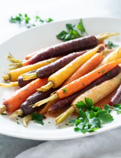 Maple glazed carrots on a platter with fresh parsley