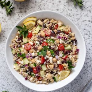 Greek quinoa salad in a white bowl