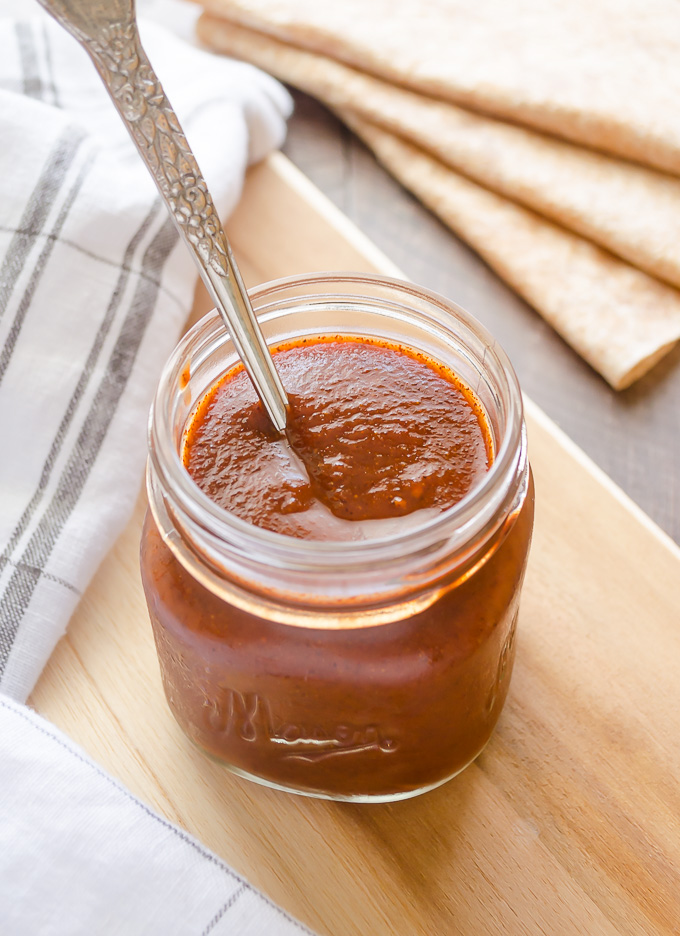 Spoon nestled in a jar of homemade enchilada sauce