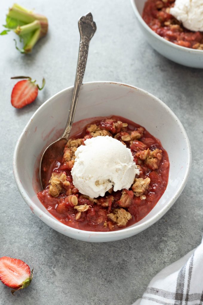 Strawberry rhubarb crisp in a bowl with ice cream