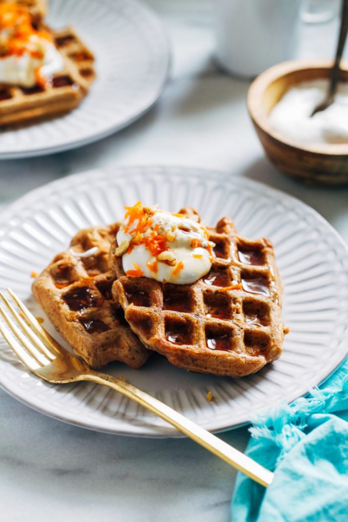 Two carrot cake waffles on a white plate.