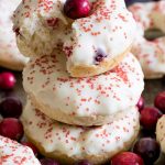 A stack of three glazed cranberry donuts.