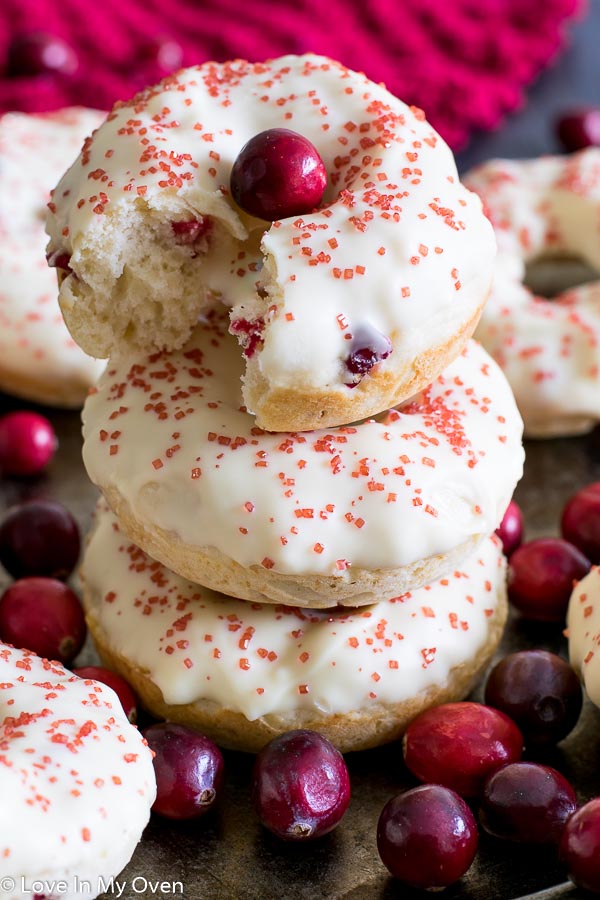 A stack of three glazed cranberry donuts.