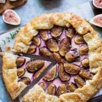 Overhead view of a fig and goat cheese galette. One slice has been cut and is about to be removed.
