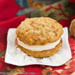 A carrot cake whoopie pie on a white plate.