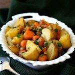 Potatoes and carrots in a white serving dish.