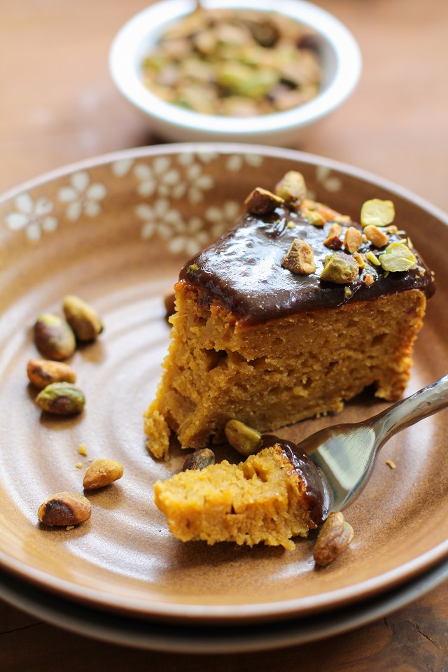 A slice of kabocha squash cake on a brown floral plate. A bite has been speared on a fork.