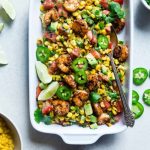 Baking dish of Mexican corn salad with honey lime shrimp.