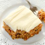 A slice of pineapple carrot cake on a white plate.