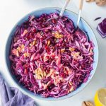 Overhead view of a blue bowl of red cabbage apple slaw.