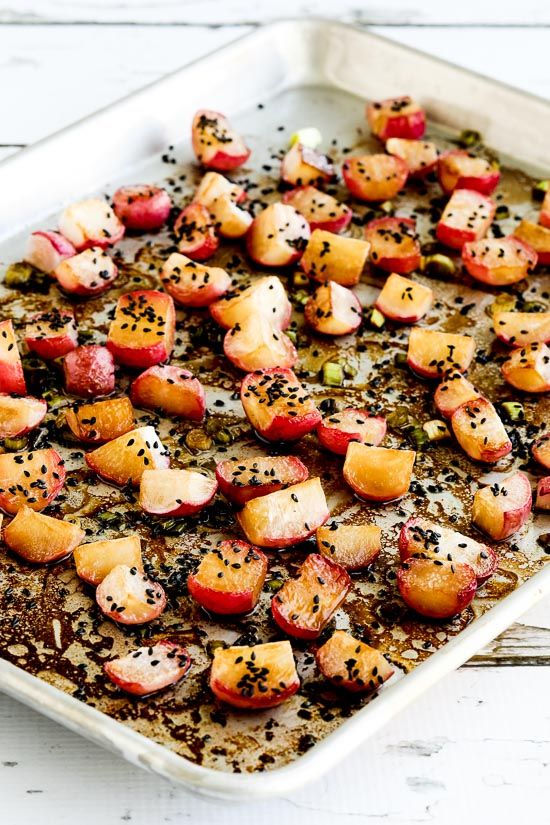 Roasted radishes with sesame seeds on a baking sheet