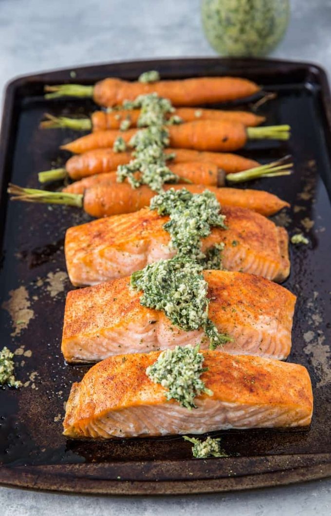 Salmon fillets and carrots on a sheet pan.