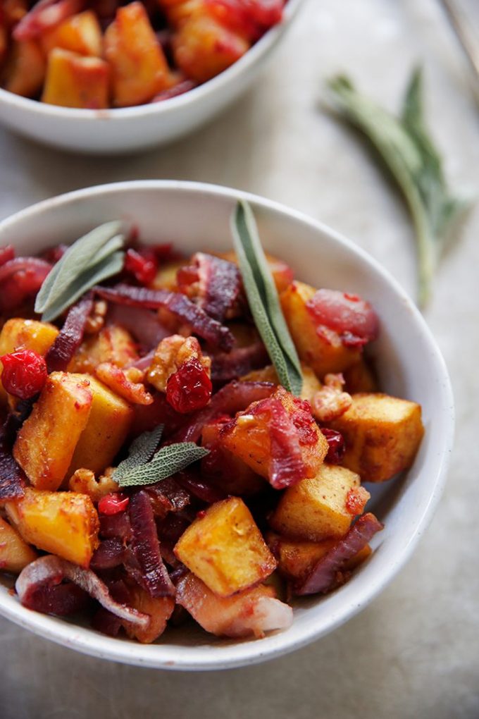 A bowl of roasted acorn squash with cranberries.