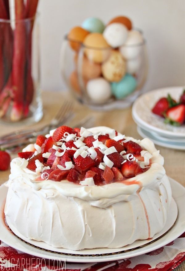 A strawberry rhubarb pavlova on a white platter.