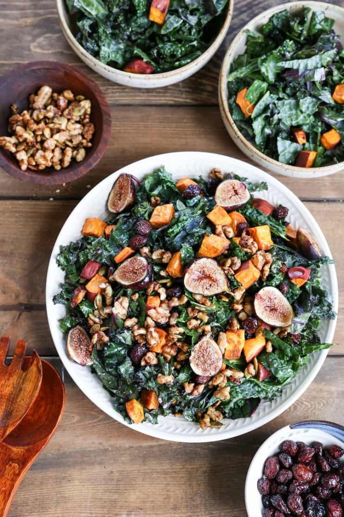 Kale salad topped with sweet potato cubes, halved figs and other veggies.