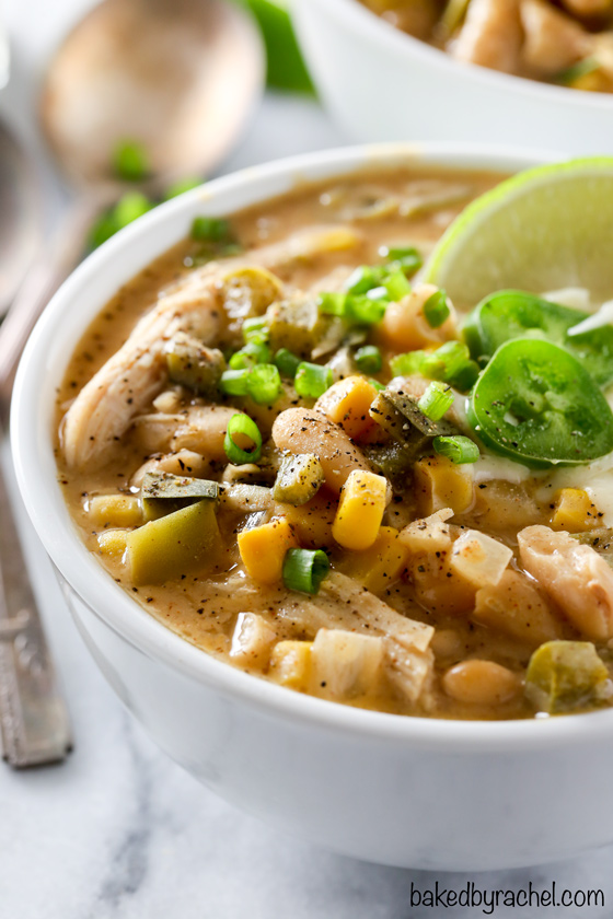 A bowl of white bean chicken chili garnished with jalapeno and lime wedge.