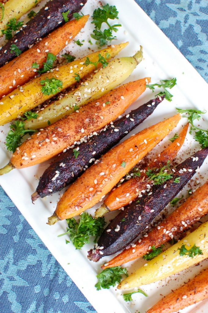 Overhead view of roasted carrots on a white platter.