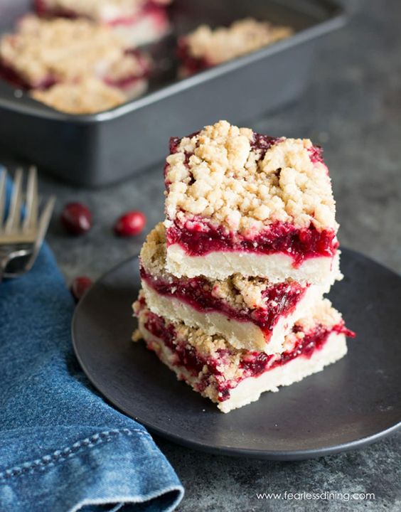 A stack of three cranberry shortbread bars on a dark gray plate.