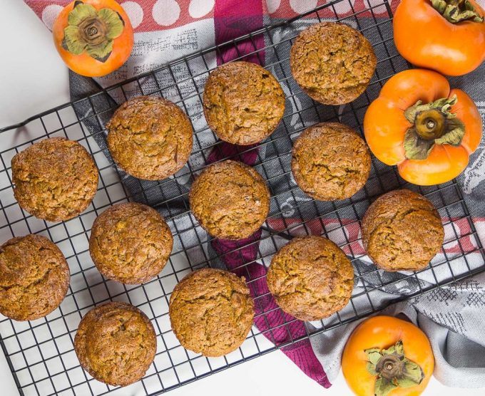 Overhead view of persimmon muffins on a wire cooling rack.