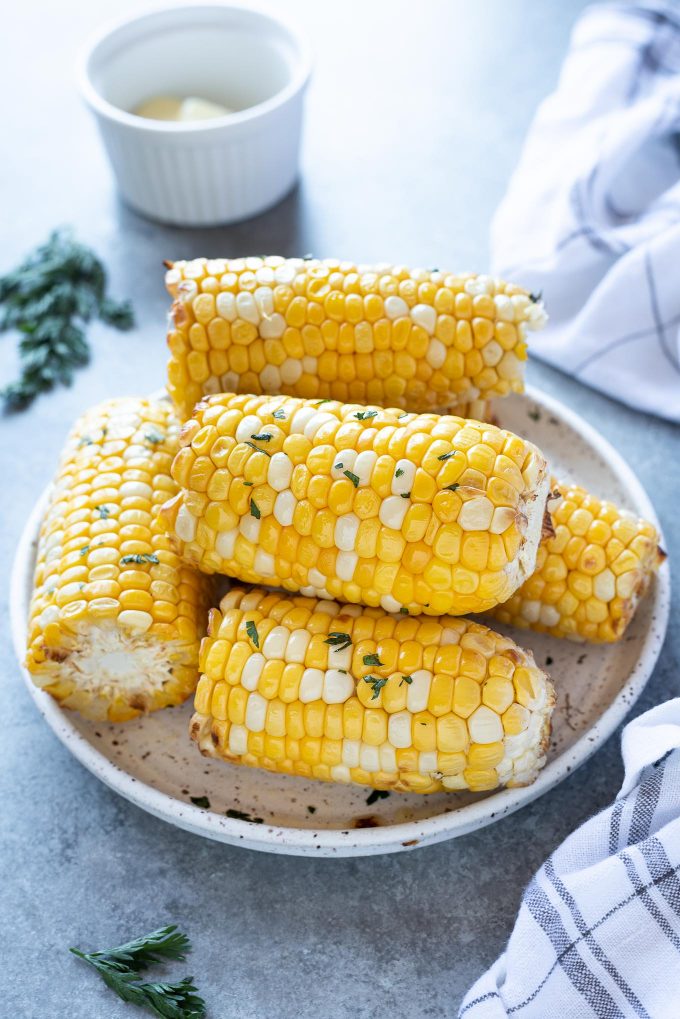 Air fryer corn on the cob piled on a white plate
