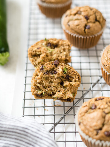 Oat flour zucchini chocolate chips muffins on a wire rack.