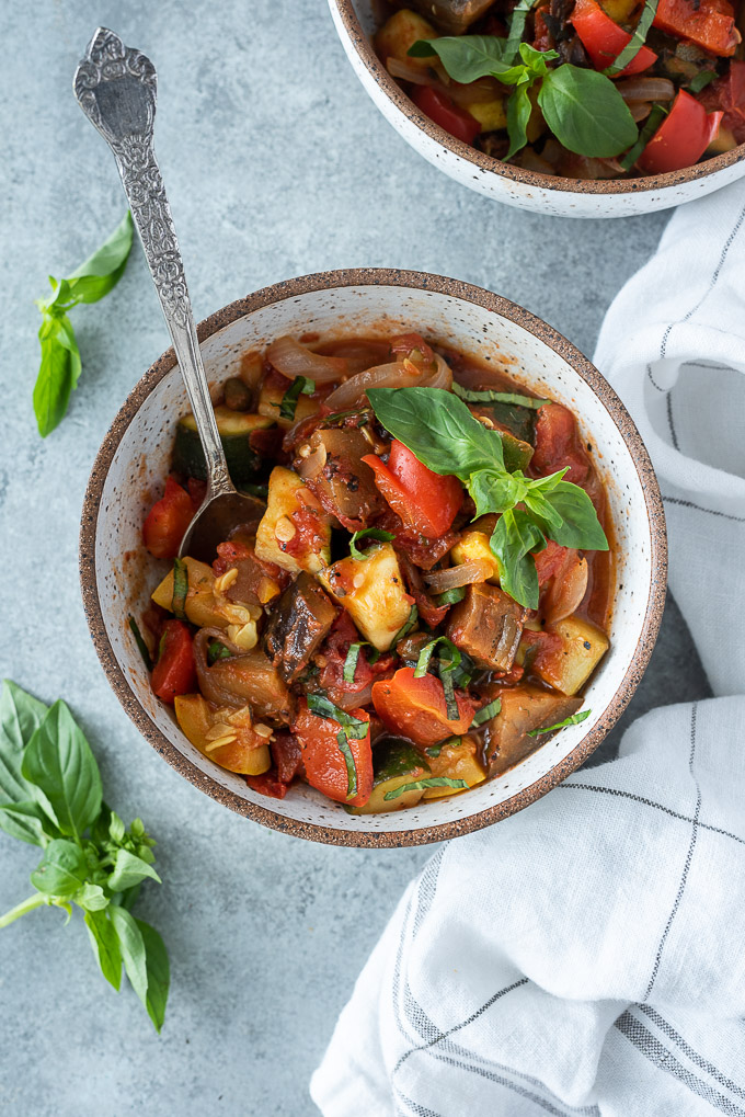 Bowl of ratatouille with a spoon buried inside