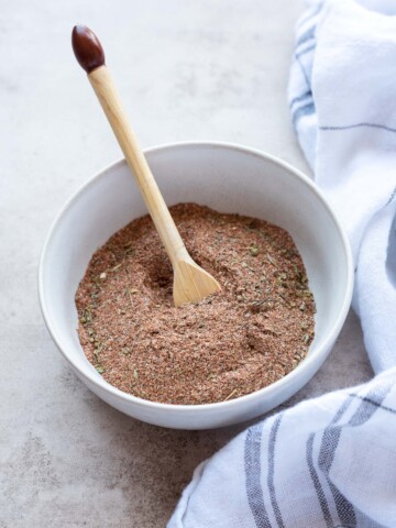 Blackened seasoning in a white bowl with a spoon nestled inside