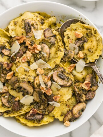 Mushroom ravioli in a serving bowl with a spoon