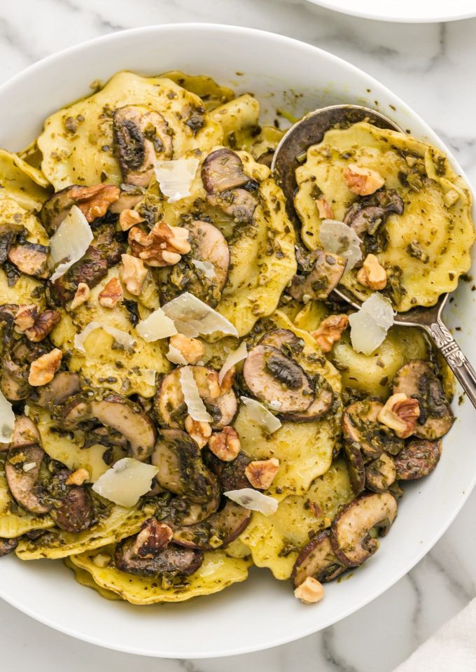 Mushroom ravioli in a serving bowl with a spoon