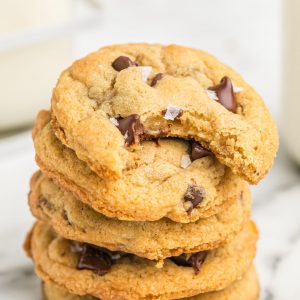 Stack of chewy chocolate chip cookies with bite out of top cookie