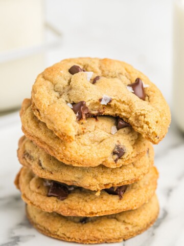 Stack of chewy chocolate chip cookies with bite out of top cookie