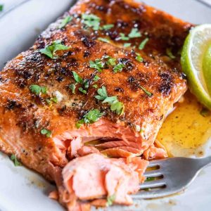 Blackened salmon on a plate with a fork flaking a corner