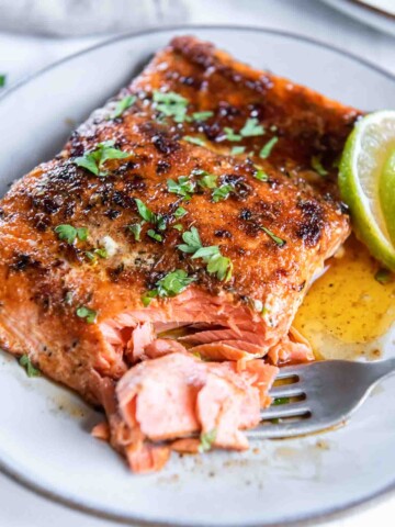 Blackened salmon on a plate with a fork flaking a corner