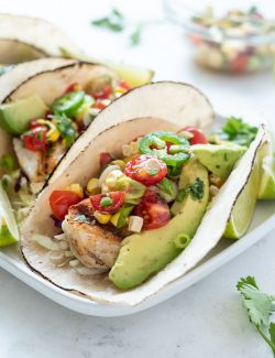 Grilled Fish Taco topped with cherry tomato salsa and avocado