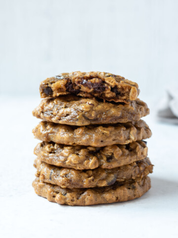 Stack of peanut butter banana oatmeal cookies with top cookie in half