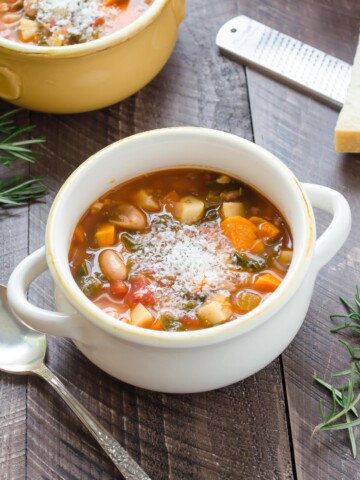 Winter minestrone soup in a white bowl with parmesan on top