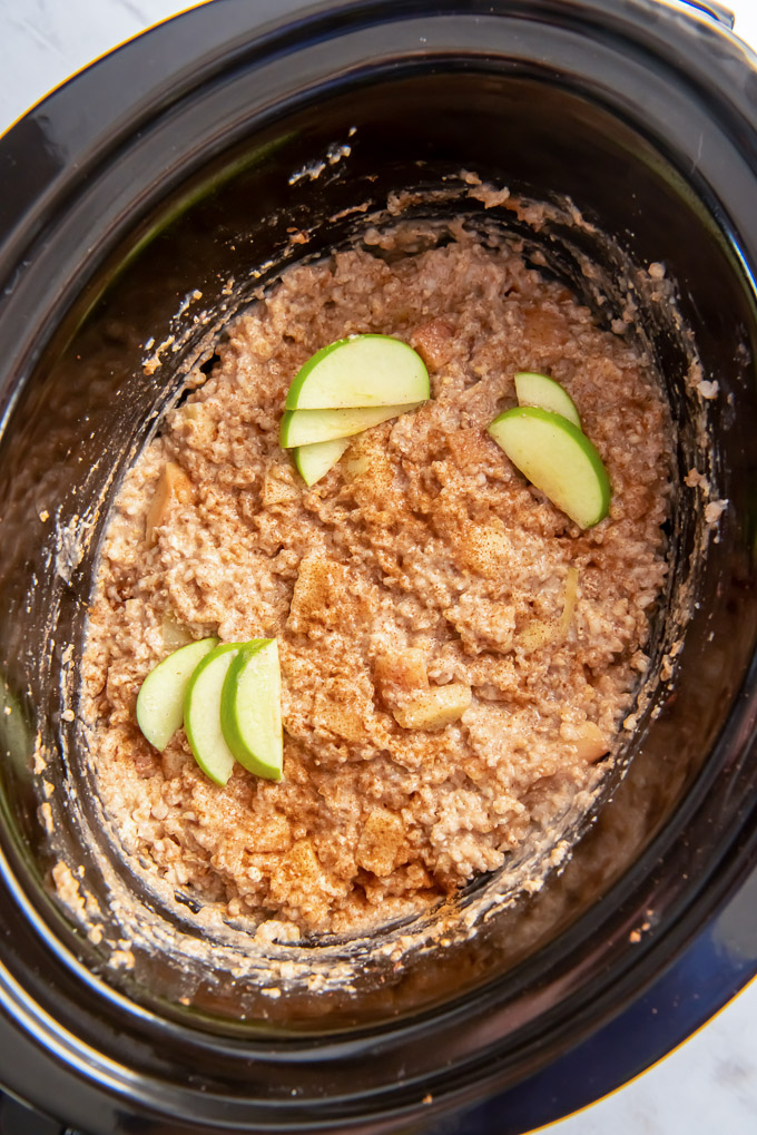 Crockpot steel cut oats in the slow cooker with apple slices on top