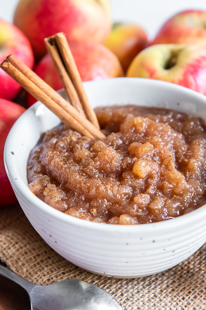 Homemade applesauce in a white bowl with cinnamon on top