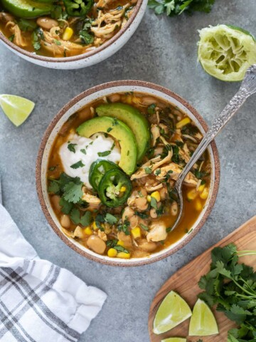 Bowl of instant pot white chicken chili with spoon digging in