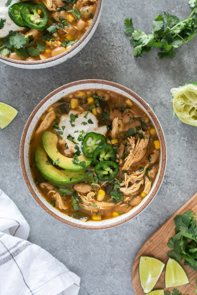 White bean chicken chili in a bowl topped with avocado and sour cream