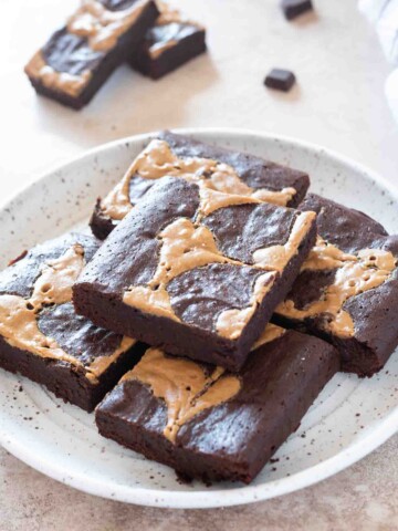 Peanut butter brownies piled on a white plate